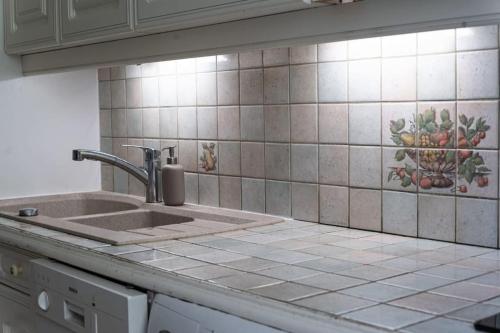 Il dispose d'une cuisine avec un évier et un mur carrelé. dans l'établissement Superb house at Nation, à Paris