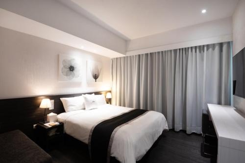 a hotel room with a bed and a television at Stay Inn in Taipei