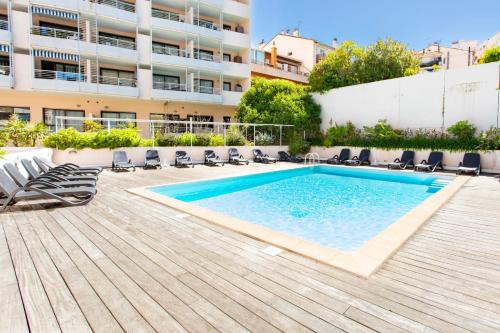 une piscine avec des chaises et un bâtiment dans l'établissement Studio Cannes 10 min Palais Festivals & Sea - AC & Pool, à Cannes