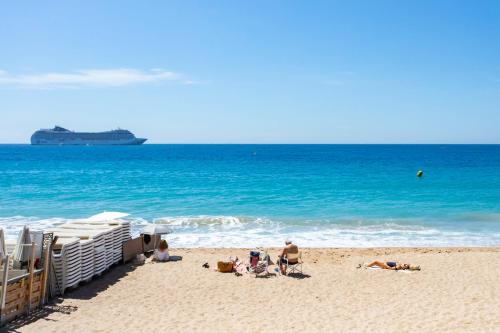 un groupe de personnes sur une plage avec un bateau de croisière dans l'établissement Studio Cannes 10 min Palais Festivals & Sea - AC & Pool, à Cannes