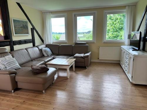 a living room with a couch and a tv at Landferienwohnung 1 Danneborth in Danneborth