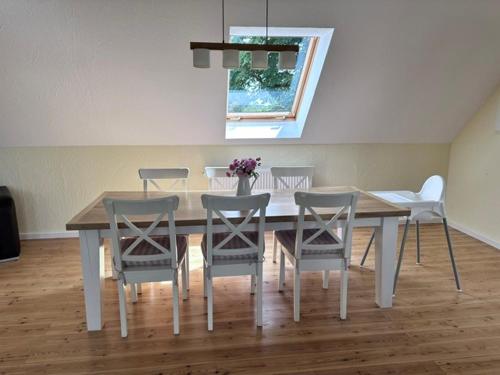 a dining room table and chairs with a table and a window at Landferienwohnung 1 Danneborth in Danneborth