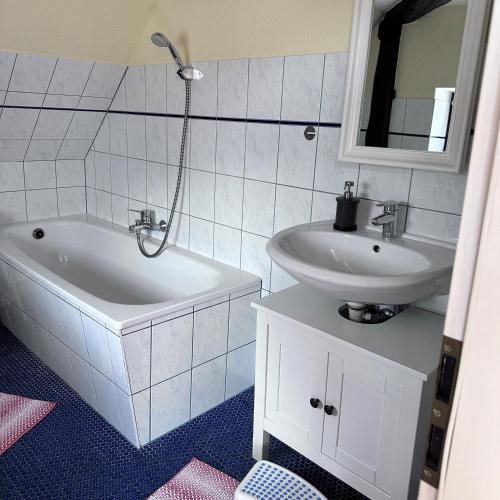 a bathroom with a sink and a bath tub and a sink at Landferienwohnung 1 Danneborth in Danneborth