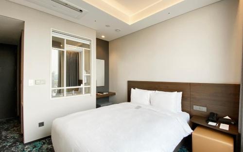 a bedroom with a large white bed and a window at HOTEL in 9 Gangnam in Seoul