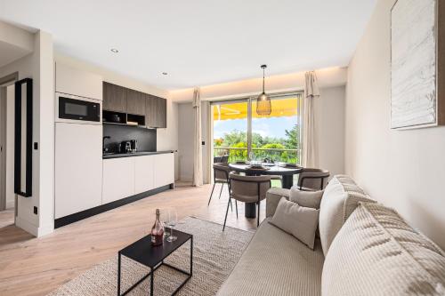 un salon avec un canapé et une table dans l'établissement L'OREE DU CAP-Somptueux 2 pièces- Garage- Terrasse, à Roquebrune-Cap-Martin