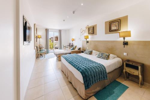 a bedroom with a bed and a living room at Hôtel Liberata & Spa in LʼÎle-Rousse