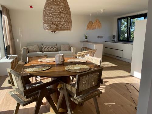 a kitchen and living room with a table and chairs at Appartementen Sonnenhof in De Koog
