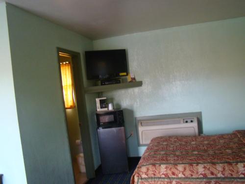 um quarto de hotel com uma cama e uma televisão em Budget Inn Mount Airy em Mount Airy