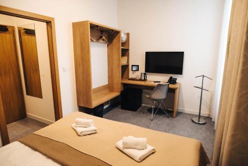 Una televisión o centro de entretenimiento en Hotel Forea