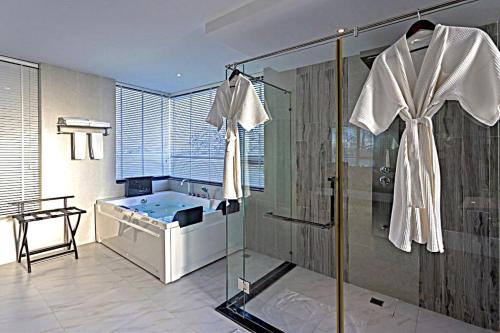 a bathroom with a shower and a bath tub at Castle Bayview Resort & Spa in Kampot