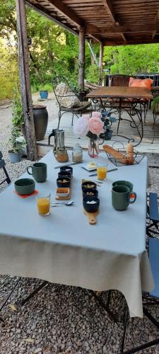 een tafel met kommen en kopjes erop bij Le Camp in Varen