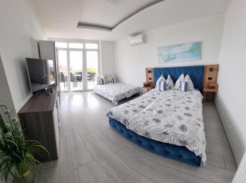 a bedroom with a large bed and a television at Lakeview Apartments Balatonfüred in Balatonfüred