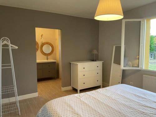 a bedroom with a bed and a dresser and a mirror at Gite de Morlannes - Nogaro, Barbotan in Marguestau