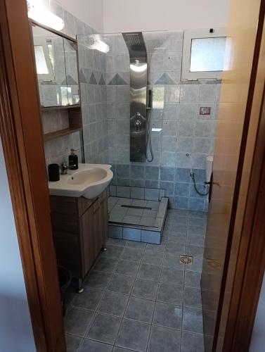 a bathroom with a shower and a sink at Villa savvas in Paralía Avdhíron