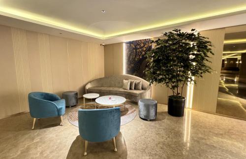 a living room with a couch and a table and chairs at Astara Hotel Balikpapan in Balikpapan