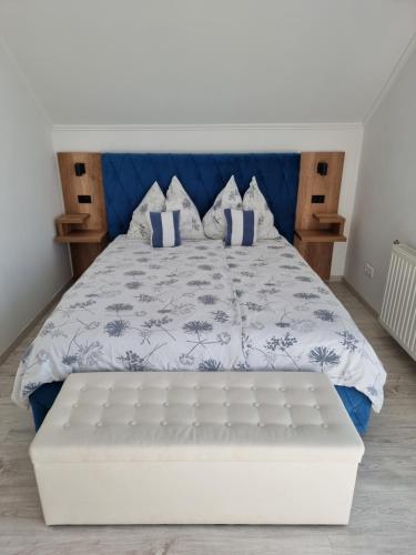 a bedroom with a large white bed with blue sheets and pillows at Lakeview Apartments Balatonfüred in Balatonfüred