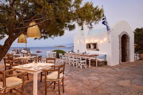 a restaurant with tables and chairs in front of the ocean at St. Nicolas Bay Resort Hotel & Villas in Agios Nikolaos