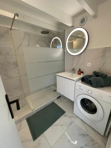 La salle de bains est pourvue d'un lave-linge et d'un miroir. dans l'établissement Studio entre Paris et Versailles, à Ville-dʼAvray
