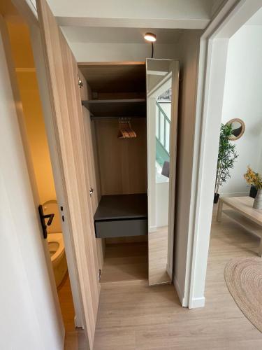 un petit couloir avec un miroir et un placard dans l'établissement Studio entre Paris et Versailles, à Ville-dʼAvray