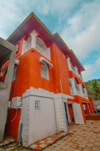 an orange building with a white door and a balcony at Mountains View Villa in Freetown