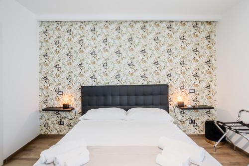 a bedroom with a white bed and a floral wallpaper at Pietramare Luxury Suites in Bari