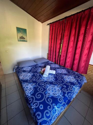 a bed with a doll laying on it in front of a window at Fare Para in Vaitoare