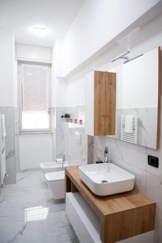 a white bathroom with a sink and a toilet at Nuova Arte - Dal Lago di Como allo Stadio in Como