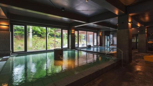 a swimming pool in a building with a large window at Kiki Shiretoko Natural Resort in Shari