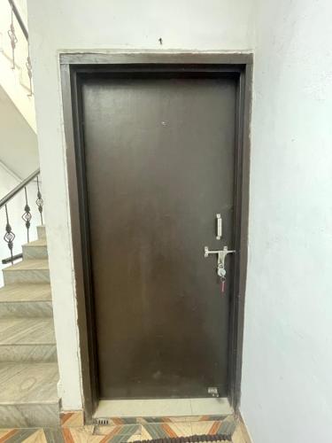 a black door in a hallway with stairs at Mangalyam Home stay in Haridwār