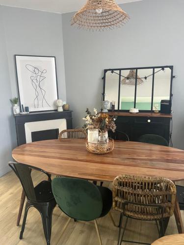 une salle à manger avec une table et des chaises en bois dans l'établissement Jolie mancelle proche centre (idéal 24h du Mans), au Mans