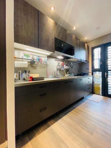 a kitchen with brown cabinets and a sink and a counter at 萊恩晴旅包棟民宿 in Magong