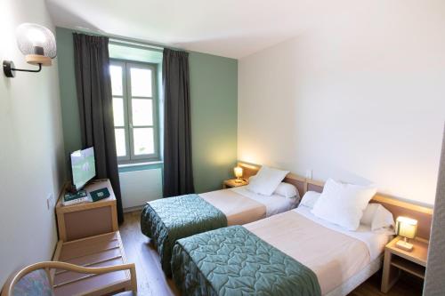 Postel nebo postele na pokoji v ubytování Logis Hôtels - Hostellerie des Lauriers - Hôtel et Restaurant