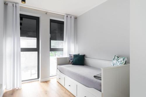 a white room with a bench in front of windows at Mi Bella II in Gdynia