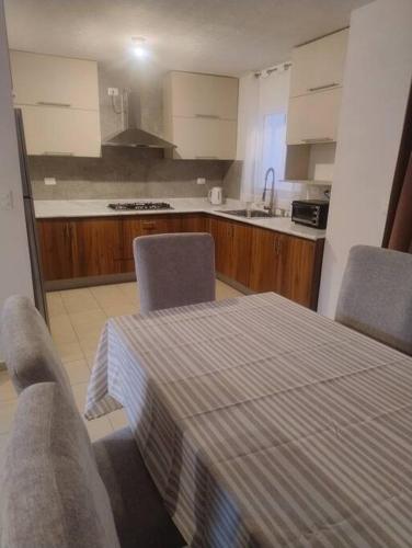 a kitchen with a table and two chairs and a kitchen with a sink at Linda Casa in Acayuca