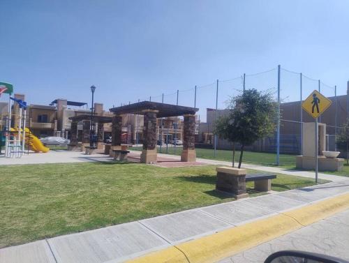 a park with benches and a playground with buildings at Linda Casa in Acayuca