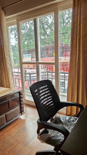 a black chair sitting in front of a window at AK Homestay in Dehradun