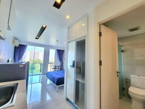 a bathroom with a toilet and a bed in a room at Nice studio comfortable in Pattaya Central