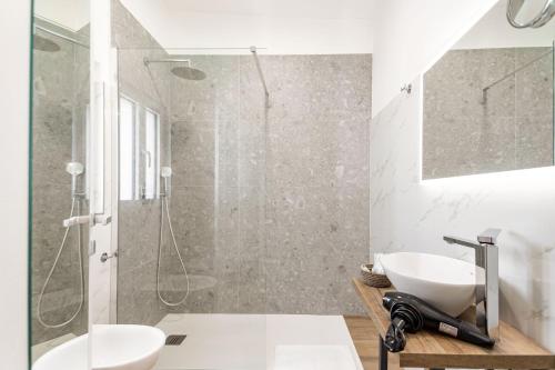 a white bathroom with a shower and a sink at Pietramare Luxury Suites in Bari
