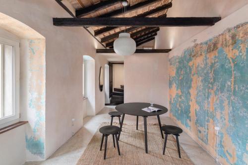 a table and stools in a room with a map on the wall at Piccolo Hotel in Vodnjan