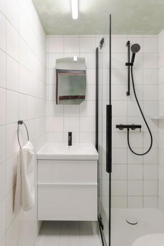 a white bathroom with a shower and a sink at Piccolo Hotel in Vodnjan