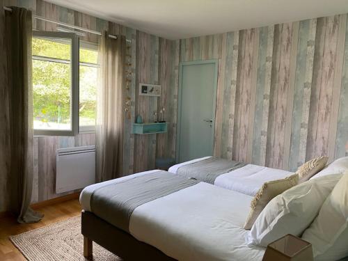 une chambre avec deux lits et une fenêtre dans l'établissement Villa Bleu Bassin & Spa - Bassin d Arcachon, au Teich