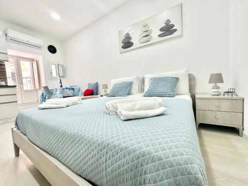 a bedroom with a large bed with blue and white sheets at Ale & Andry House in Cefalù