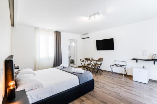 a white bedroom with a bed and a table and chairs at Pietramare Luxury Suites in Bari