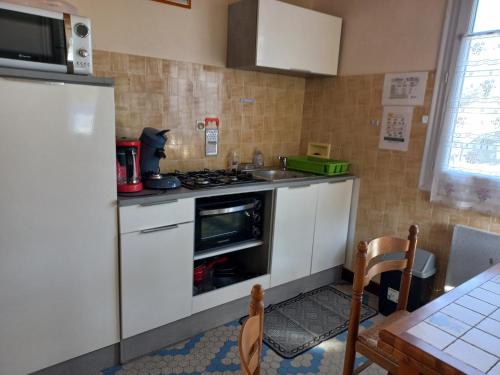une cuisine avec un évier et une cuisinière four supérieur dans l'établissement Maison Oleron, à Les Sables Vignier