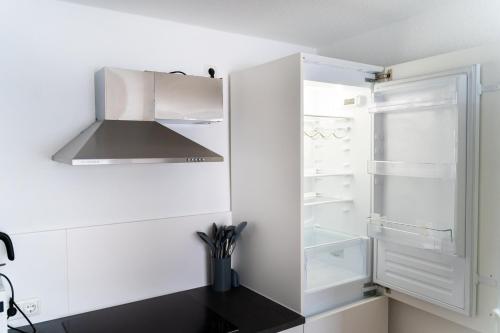 a white kitchen with a hood and an empty refrigerator at Monteurswohnung nähe Mainz 5 Schlafzimmer in Gabsheim