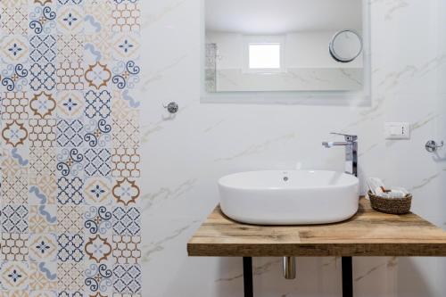 a white bathroom with a sink and a mirror at Pietramare Luxury Suites in Bari