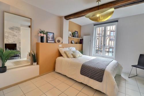 une chambre avec un lit et une grande fenêtre dans l'établissement Le Petit Vauluisant - Cosy & Confort - Mon Groom, à Troyes