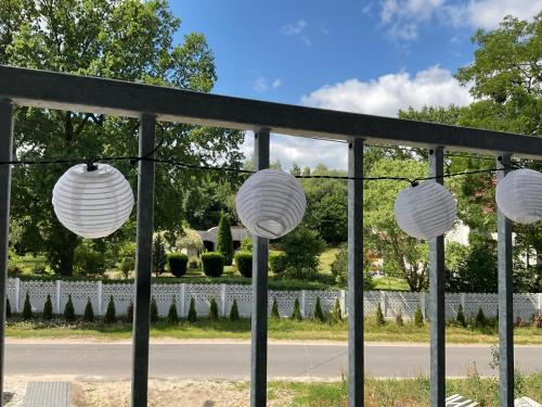 a group of white paper lanterns in front of a fence at Apartament Jerzyn in Jerzyn