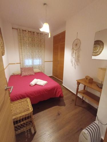 een slaapkamer met een rood bed en een tafel bij CHIBITEL Alojamiento Rural in Córdoba