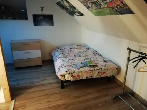 - un petit lit dans un coin de chambre dans l'établissement Maison de campagne 12 personnes, à Villeloup